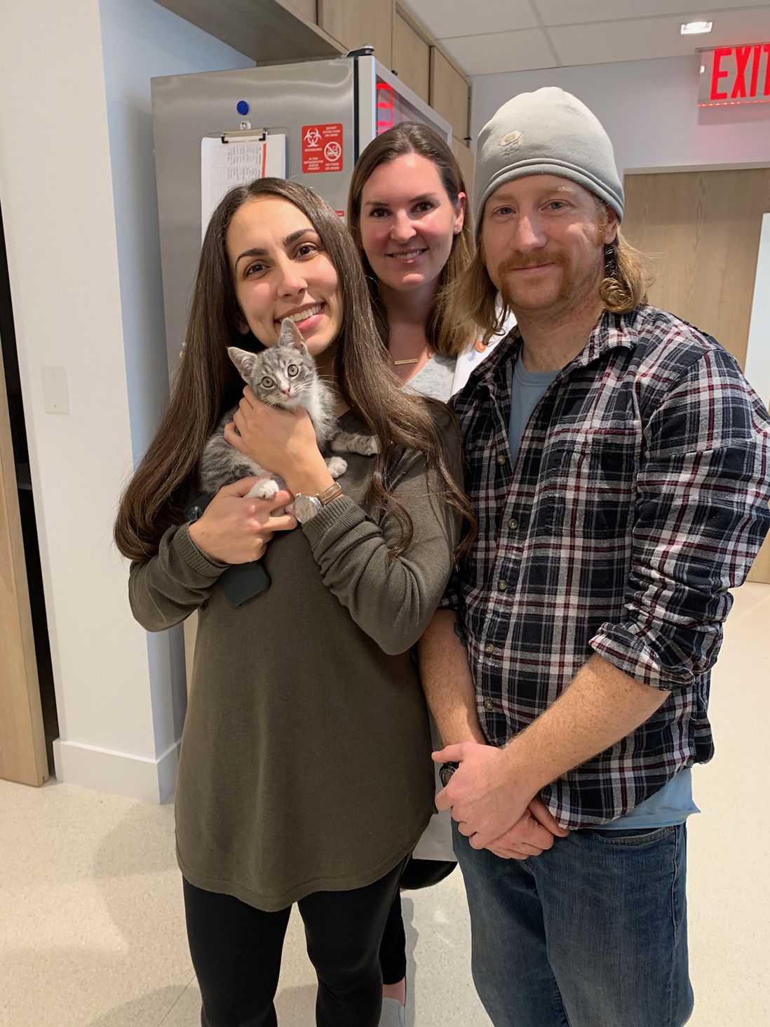 Jenna, the bystander who spotted Franklin scamper into a car, holds him while posing with Firefighter Dan Wiwczar and Dr. Jamie Richardson